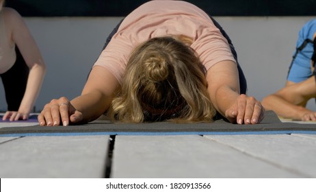 Group Of Adults Peoples Doing Yoga Outdoors On The Roof Of The House. Outdoor Group Yoga Classes Back View. Many People Do Yoga Exercises. Meditation And Wellness Lifestyle Concept