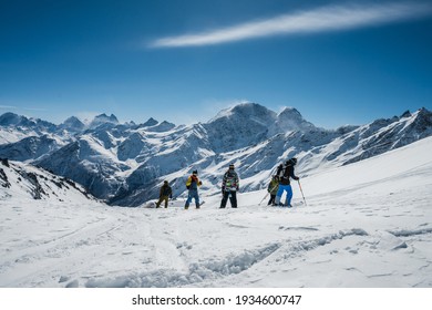 Group adventures. A group of freeriders on skis and snowboards rides in the mountains on snow.