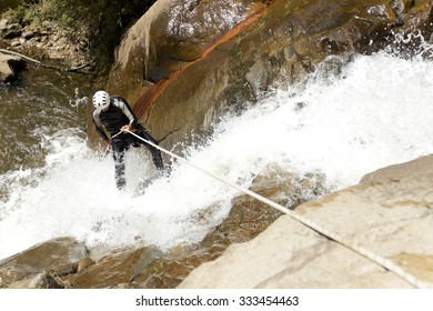 A group of adventurous climbers descending a steep rock canyon in Ecuador, surrounded by breathtaking waterfalls and challenging terrain. - Powered by Shutterstock