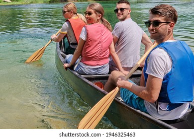 Group Adventurous Explorer Friends Are Canoeing In A Wild River