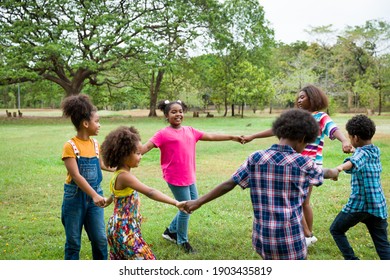 Group of African American children joining their hands in the park. Cheerful diverse black children raising their hands. Successful and teamwork concept - Powered by Shutterstock