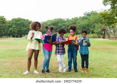 Group Of African American Children Learning And Writing Book In The Park. Diversity Black People Learning Outside The Classroom. Kids Field Trips Outside. Kids And Educational Concept