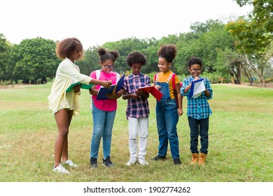 Group Of African American Children Learning And Writing Book In The Park. Diversity Black People Learning Outside The Classroom. Kids Field Trips Outside. Kids And Educational Concept