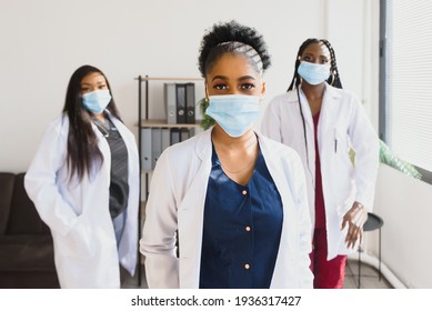 Group of African American female doctors in protective masks on their faces - Shutterstock ID 1936317427