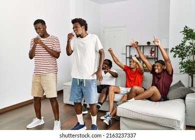 Group Of African American People Having Party Singing Song At Home.