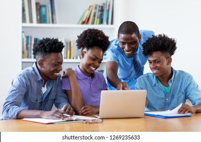 Group Of African American Students With Male Teacher At University