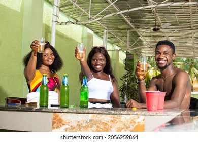 Group Of African Friends Having Drinks At A Bar Raising Their Glasses