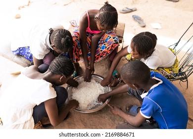 Group of African village children sharing a simple rice meal; concept of scarcity of food and malnutrition in developing countries - Shutterstock ID 2169884671