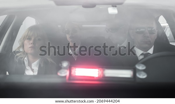Group of\
agents protect celebrity vip person in the car limousine with\
signal patrol light. Bodyguard and VIP person security protection.\
Professional police agent in civilian black\
suit