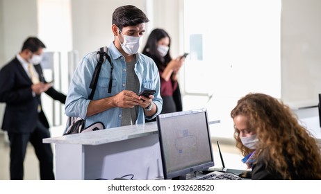 Group Of Airline Tourist Traveler Wearing Face Mask Waiting For Luggage Loading And Boarding Pass At Airport Check-in Counter. Airline Employee Staff Wearing Face Mask When Working With Colleagues.