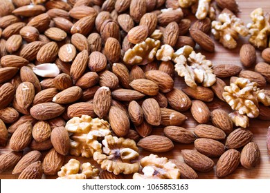 Group of almonds and walnuts on wood background - Shutterstock ID 1065853163