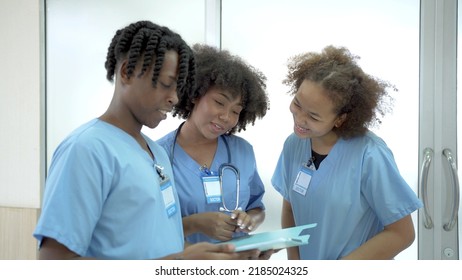 Group Of American - African Ethnicity Medical Student Or Intern Doctor In General Hospital Making A Discussion Together About Symptomatic Treatment, Happy Medical Student Talking. Healthcare Worker.