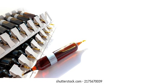 Group Of Ampoules With A Transparent Medicine In Medical Laboratory. Horizontal Perspective View Of Many Brown Ampoules Set In Pharmaceutical Packaging White Container