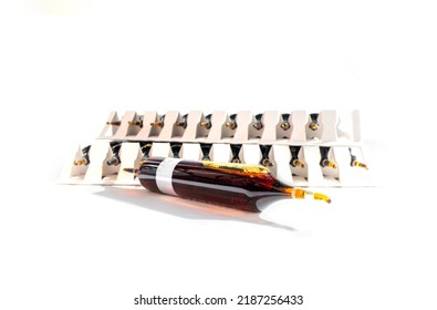 Group Of Ampoules With A Transparent Medicine In Medical Laboratory. Horizontal Perspective View Of Many Brown Ampoules Set In Pharmaceutical Packaging White Container