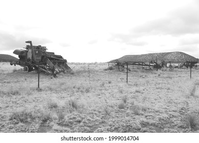 A group of antique pieces of farm equipment, from the time when pinto beans were dry-land farmed on the high desert of New Mexico, on display by the side of the road.