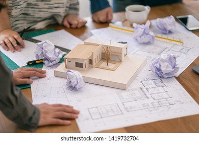 Group of an architect feel stressed after working on architecture model together with shop drawing paper on table in office - Shutterstock ID 1419732704