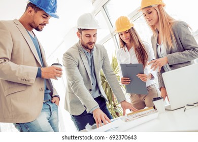 Group of architects correcting a construction plan in the office.