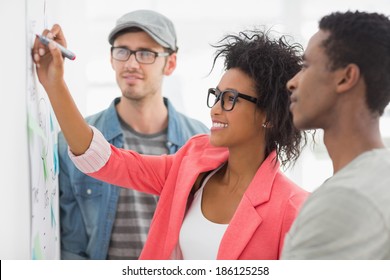 Group Of Artists In Discussion In Front Of Whiteboard At Office