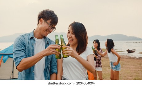 Group of Asia best friends teenagers focus on couple toast beer enjoy camping party with happy moments together beside tents in national park. On the background beautiful nature, mountains and lake. - Shutterstock ID 2034034094