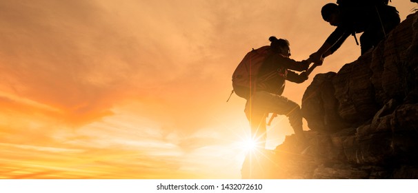 Group of Asia hiking help each other silhouette in mountains with sunlight.