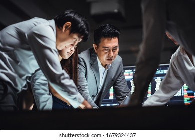 Group Of Asian Business Financial Team In Strategic Meeting, Work Late Night Shift In Office. Business Strategy Analysis, Stock Market Trading, Corporate Company, Colleague Coworker Teamwork Concept