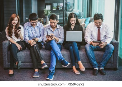 Group Of Asian Business People With Casual Suit Using The Technology Mobile, Tablet, Laptop And Computer For Working Or Social Network In Modern Office,people Business Group Concept