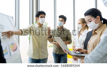 Group of asian business people meeting and working in office and wear mask for protect  prevent infection corona virus covid 19.