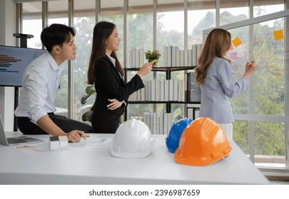 Group of Asian businesspeople and engineers working and brainstorming in office. Competent construction team having discussion during meeting. Team Architect looking at blueprints in a building site - Powered by Shutterstock