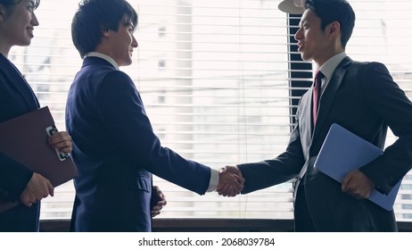 Group of asian businessperson shaking hands in the office.