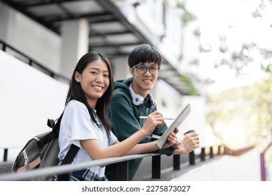 Group of Asian college student reading books and tutoring special class for exam on grass field at outdoors. Happiness and Education learning concept. Back to school concept. Teen and people theme. - Powered by Shutterstock