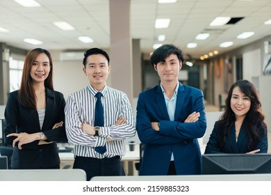 Group Of Asian Corporate Business Team In Arms Crossed Looking At Camera Standing In The Office. Confident And Positive Attitude. Success Employee And Teamwork. Financial Advisor Or Customer Support