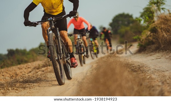 Group of Asian cyclists, they cycle through rural\
and forest roads.