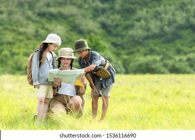 Group Asian Family Children Checking Map In The Jungle Adventure And Tourism For Destination And Leisure Trips For Education And Relax In Nature Park.  Travel Vacations And Life Concept