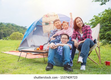 Group of asian family travel and camping in forest ,sitting all  together and smile. Family and outdoor activity concept.