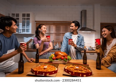 Group of Asian friend having dinner, enjoy evening party together at home. Attractive young man and woman having fun, eating food, celebrate weekend reunion gathered together at dining counter at home - Powered by Shutterstock