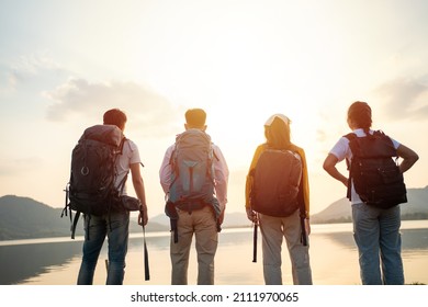 A group of Asian friends backpacking bag and walking for picnic and camping near lake