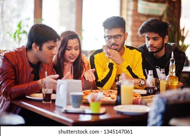 Group Of Asian Friends Eating Pizza During Party At Pizzeria. Happy Indian People Having Fun Together, Eating Italian Food And Sitting On Couch.