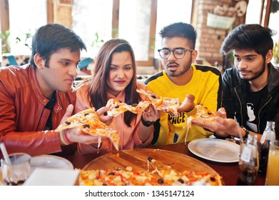 Group Of Asian Friends Eating Pizza During Party At Pizzeria. Happy Indian People Having Fun Together, Eating Italian Food And Sitting On Couch.