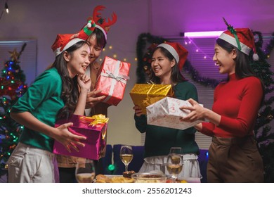 Group of Asian friends exchanging gifts During a Christmas party at home While eating a happy Thanksgiving dinner on the dining room table at home, having fun, celebrating the holiday idea. - Powered by Shutterstock