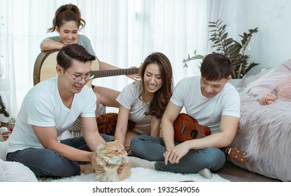 Group Of Asian Friends Having Party, Playing Guitar And Singing Together With Fun At Home. Lifestyle Concept.