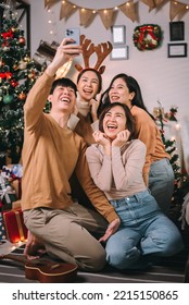 Group of asian friends make a selfie an enjoying christmas party or new year celebrating. Friends having fun together at home party.