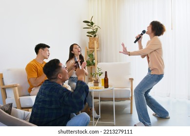 Group of Asian friends playing karaoke and sing a song at home together - Shutterstock ID 2213279111