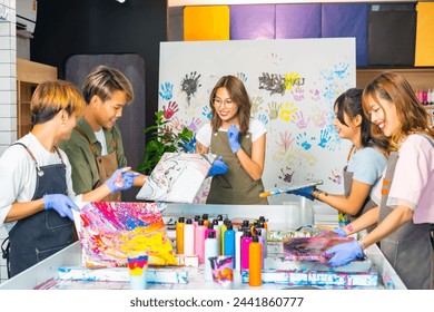 Group of Asian generation z people learning acrylic pouring art on canvas workshop at art studio. Young artist university student enjoy and fun creating colorful abstract modern art painting in class. - Powered by Shutterstock