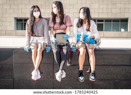 Group of asian girls going out after quarantine during coronavirus period. Young women outdoor with safety masks