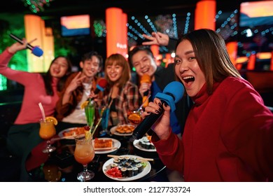 Group of asian guys and girls singing songs and making selfie at karaoke club, Group of friends having fun and celebration at karaoke club, Friends toasting with cocktails, Friendship and happiness,