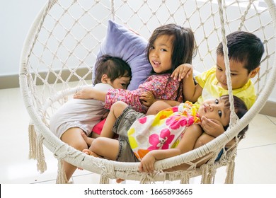 A group of asian kids playing with the indoor swing