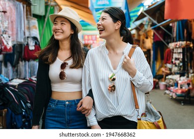 Group Of Asian Korean Women Shopping And Walking In Taipei Taiwan. Two Girls Travelers Having Fun In City While Visiting In Local Traditional Market. Tourists Friends Sharing Happy Moments Together