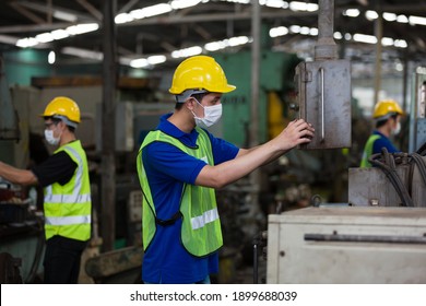 Group Of Asian Male Worker Wearing Face Mask Working At Factory. Team Of Asian Male Engineer Worker Checking, Repair Or Maintenance Machine In The Industry Factory. Industry And Health Care Concept