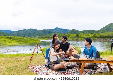 Group of Asian Man and woman friend having breakfast and drinking brewed coffee by the lake in the morning. People enjoy outdoor lifestyle travel nature and camping together on summer holiday vacation - Powered by Shutterstock