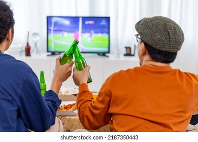 Group of Asian man and woman friends watching soccer games world cup competition on television with drinking beer together at home. Sport fans people shouting and celebrating sport team victory match. - Powered by Shutterstock